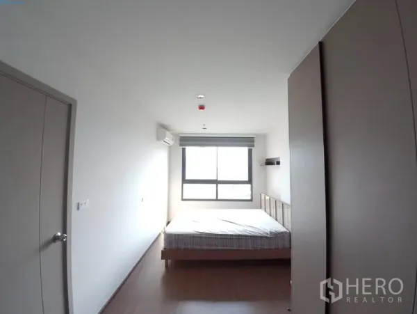 Condominium for rent in Phra Khanong, Bangkok - Bright master bedroom with double bed, large window, wardrobe and wood flooring.
