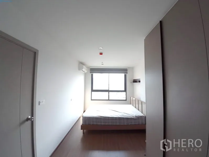 Condominium for rent in Phra Khanong, Bangkok - Bright master bedroom with double bed, large window, wardrobe and wood flooring.