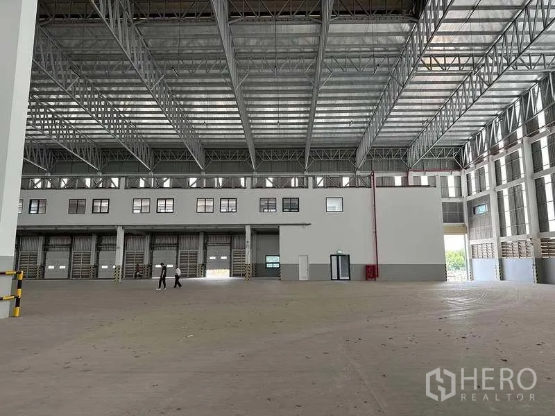 Factory for rent or sale in Samut Prakan - Large factory hall with high ceiling, loading doors and mezzanine office block.