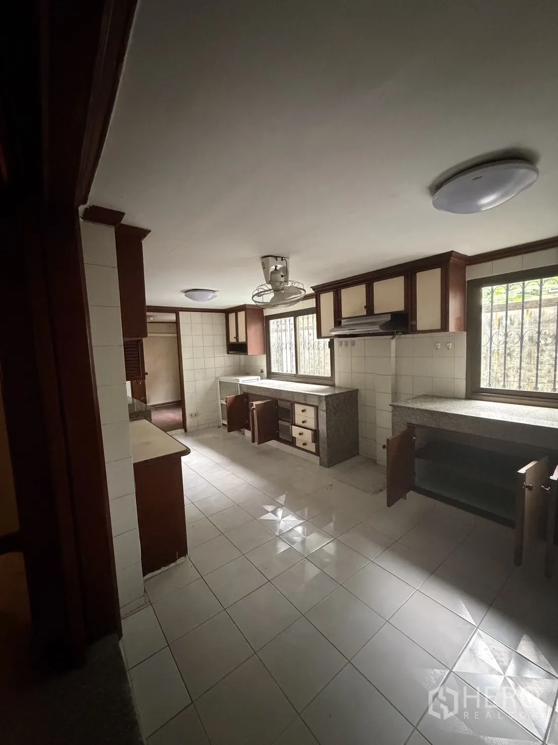 โฮมออฟฟิศ for rent in Watthana, Bangkok - ห้องครัวปูกระเบื้องกว้าง ตู้ไม้ เครื่องดูดควัน และหน้าต่างติดเหล็กดัด
