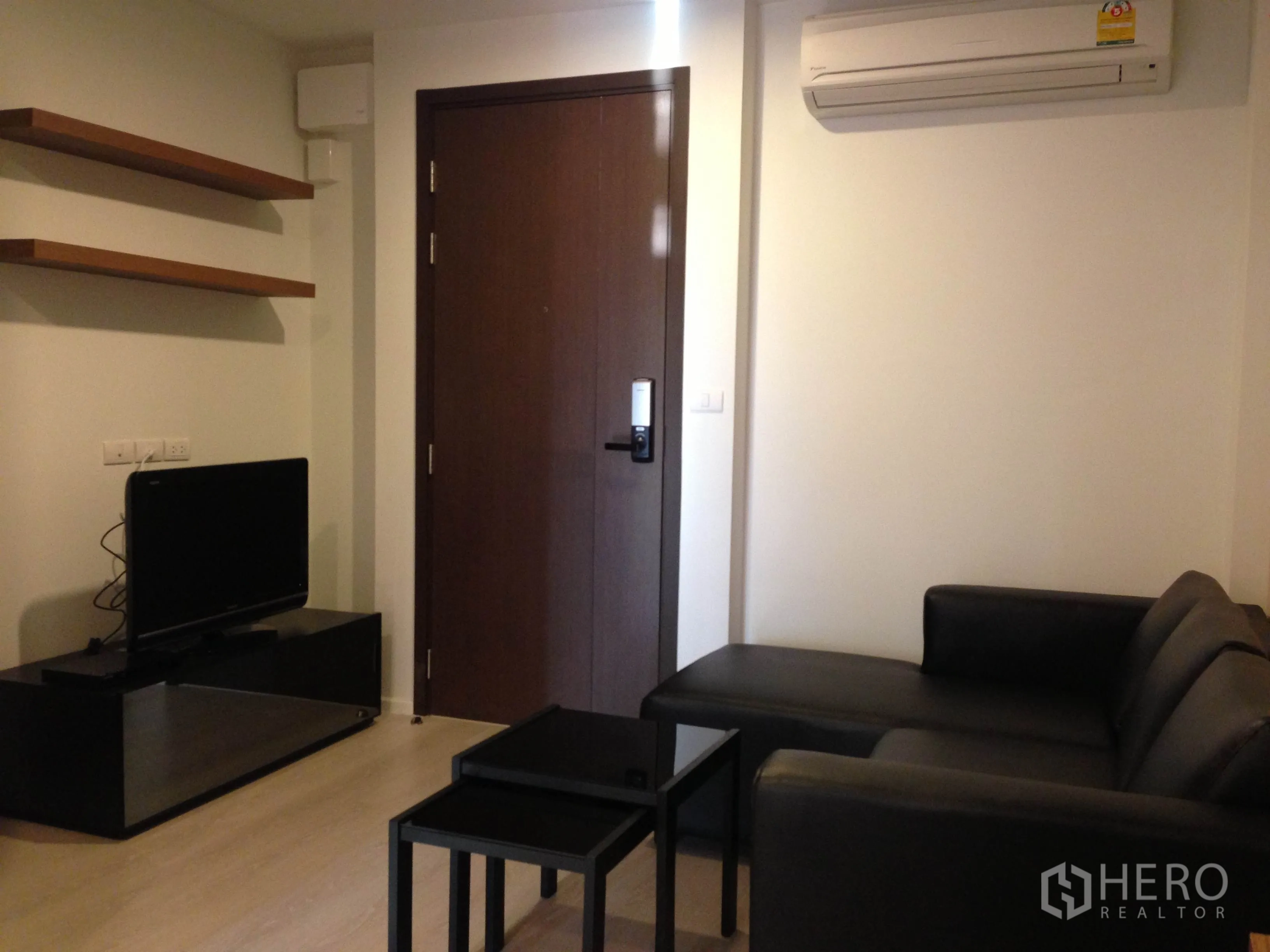 คอนโด ให้เช่าในSathon, Bangkok - มุมนั่งเล่นมีโซฟาเข้ามุม ชั้นลอย ทีวี และเครื่องปรับอากาศใกล้ประตู
