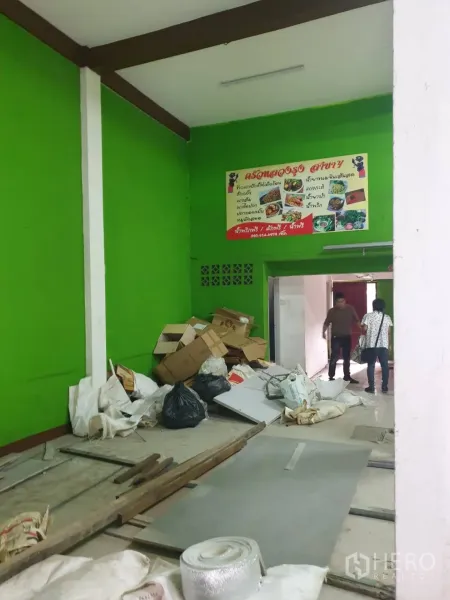 店屋 出租在Phra Khanong, Bangkok - 底层室内正在整修，鲜绿色墙面，地面堆放施工材料。