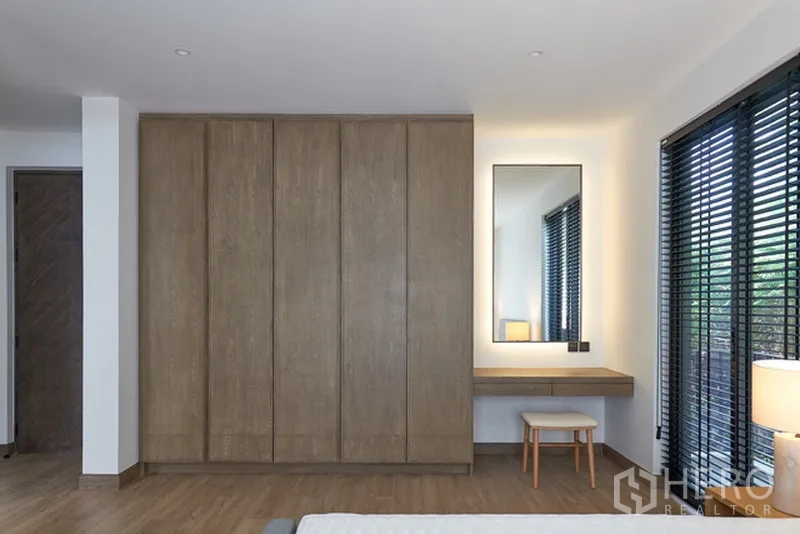 Detached House for rent in Watthana, Bangkok - Bedroom wall of fitted wardrobes with dressing table and illuminated mirror.