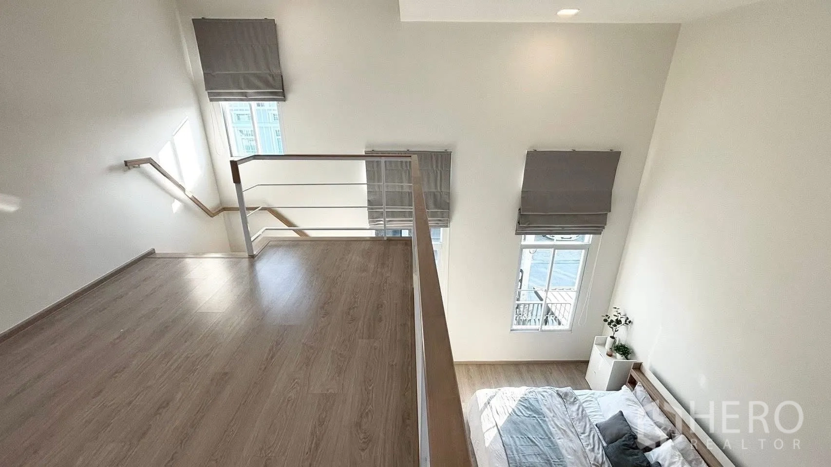 联排别墅 for rent in Prawet, Bangkok - 夹层平台带扶手，俯瞰挑高卧室与高窗。