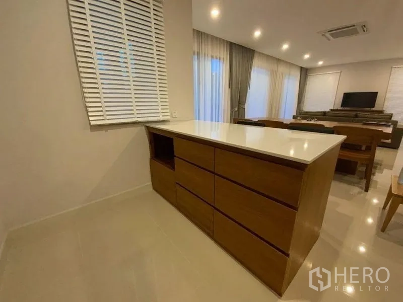 Townhouse for rent in Prawet, Bangkok - Built-in wooden island cabinet beside the dining area with recessed lighting.