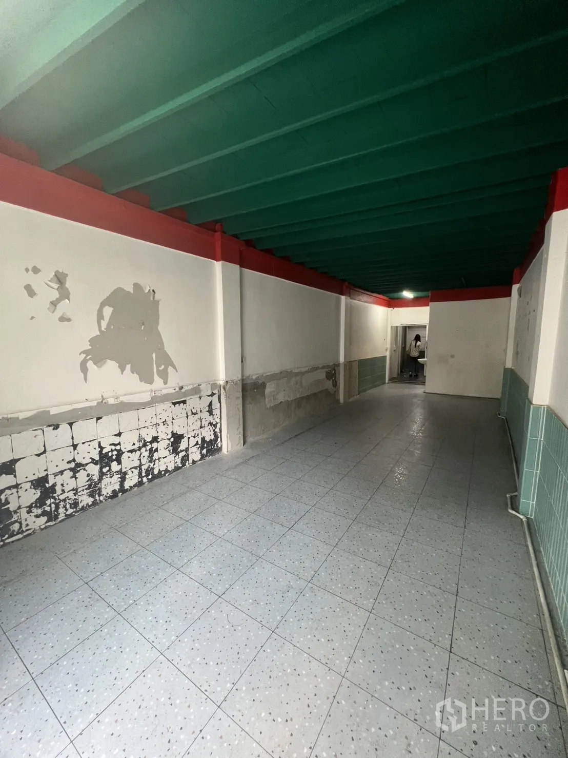 Shophouse for rent in Watthana, Bangkok - Reverse view of the ground-floor hall showing tiled walls and open layout.