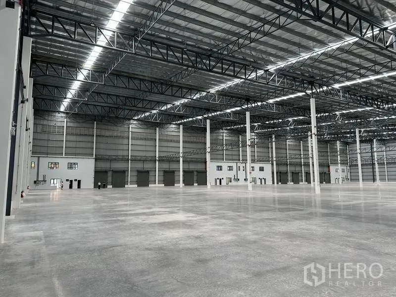 工厂 出租在Bang Phli, Samut Prakan - 仓库内部，立柱、卷闸门与明亮的LED照明。