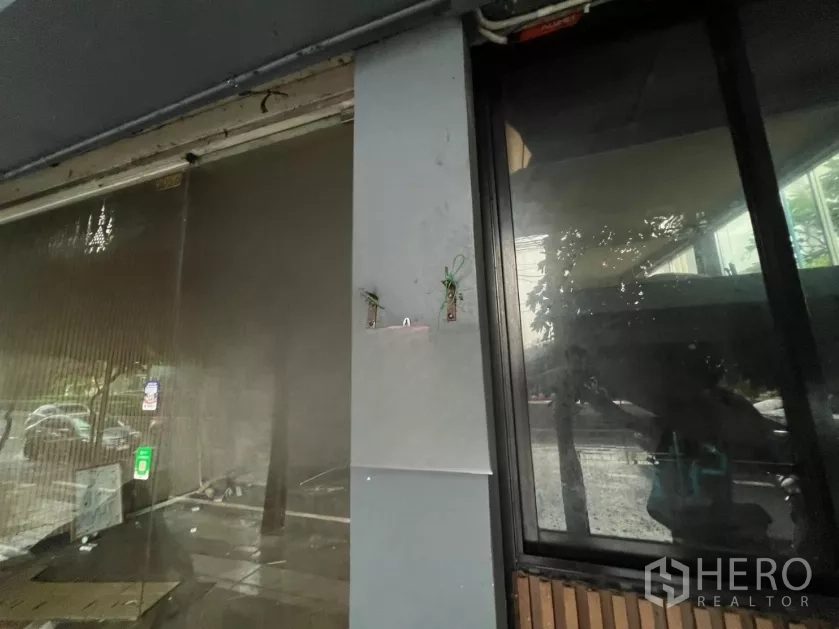 店屋 出租在Khlong Toei, Bangkok - 店面玻璃与立柱特写，可见安装位与街景倒影。