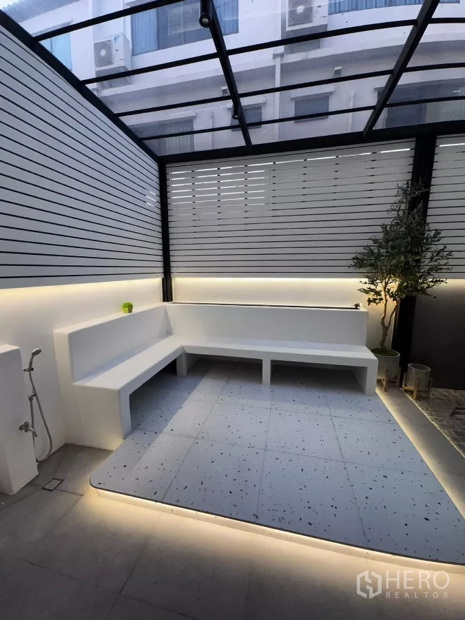 Townhouse for rent or sale in Lat Phrao, Bangkok - Covered patio with L-shaped built-in bench and ambient LED lighting.
