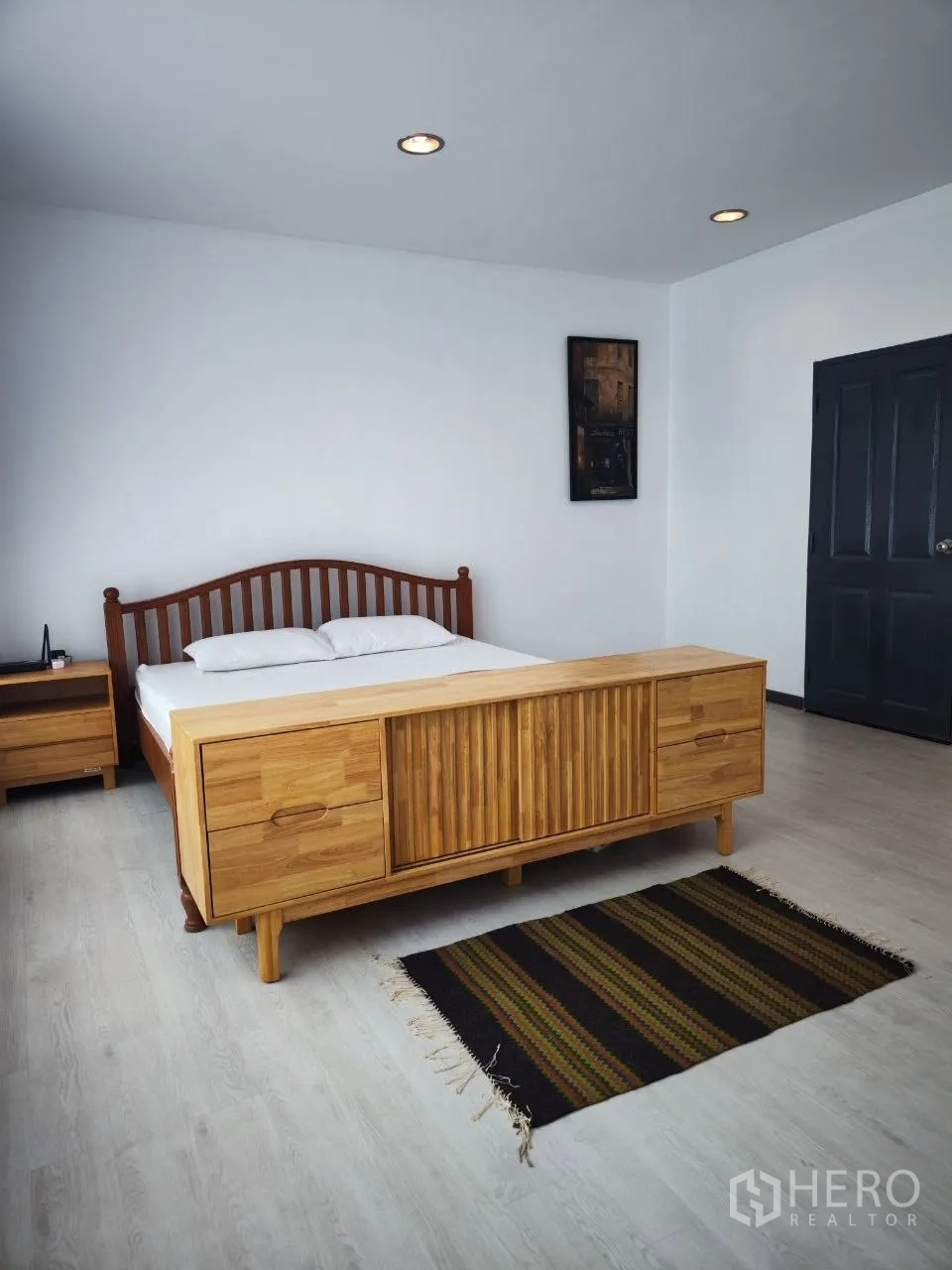 Home Office for rent in Bang Na, Bangkok - Primary bedroom with wooden bed, matching cabinet and rug.