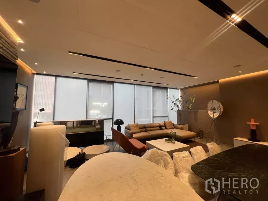 零售空间 出租 - 开放式零售室内，落地窗、筒灯与沙发接待区，旁有石材台面。