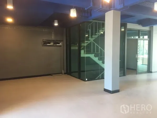 Retail Space for rent in Watthana, Bangkok - Open-plan retail floor featuring a glass-enclosed staircase and central columns.