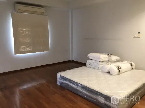 Detached House for rent in Wang Thonglang, Bangkok - Spacious bedroom with wood flooring, air-conditioner and low bed base