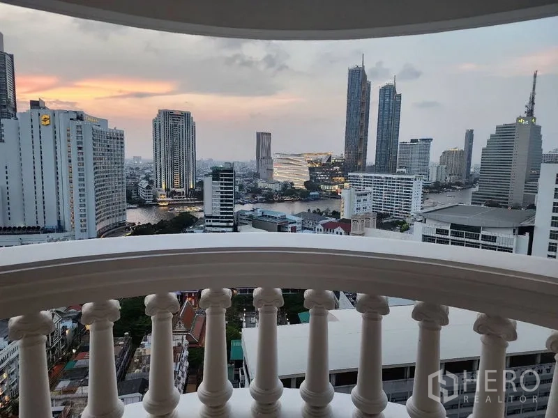 คอนโด ให้เช่าในBang Rak, Bangkok - วิวระเบียงแม่น้ำเจ้าพระยาและสกายไลน์ ICONSIAM ยามเย็น กรอบลูกกรงสีขาว