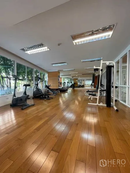 Condominium for rent - Residents’ fitness room with cardio machines, weight equipment and wooden flooring.