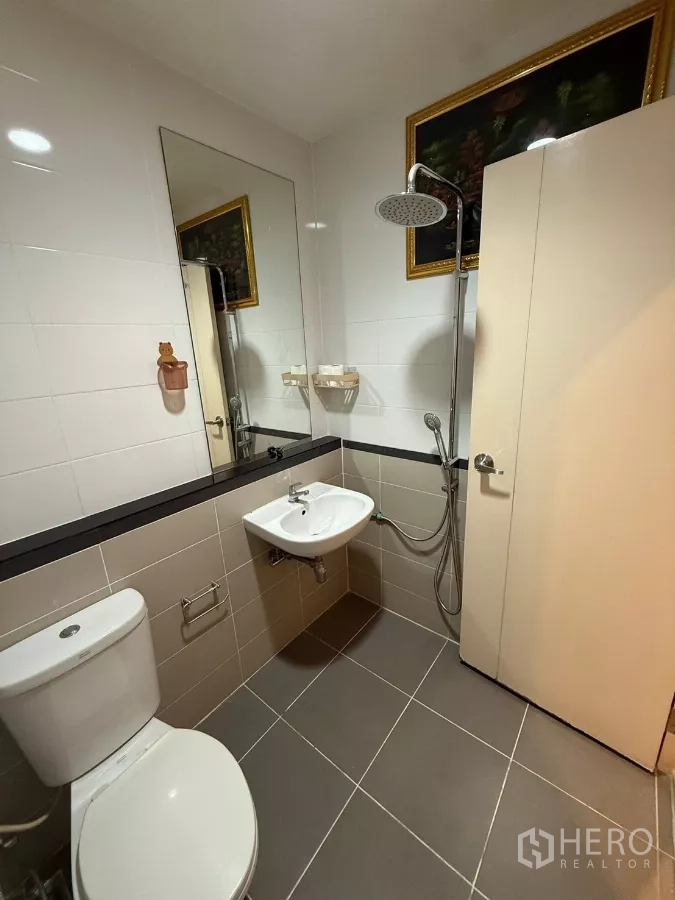 Townhouse for rent in Suan Luang, Bangkok - Second bathroom with rain shower, large mirror and two-tone tiles.