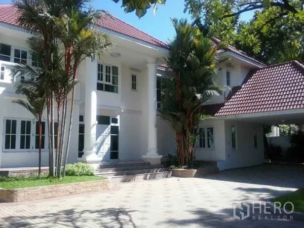 独立式住宅 出售 - 立柱门廊的优雅外立面，车棚与棕榈树。