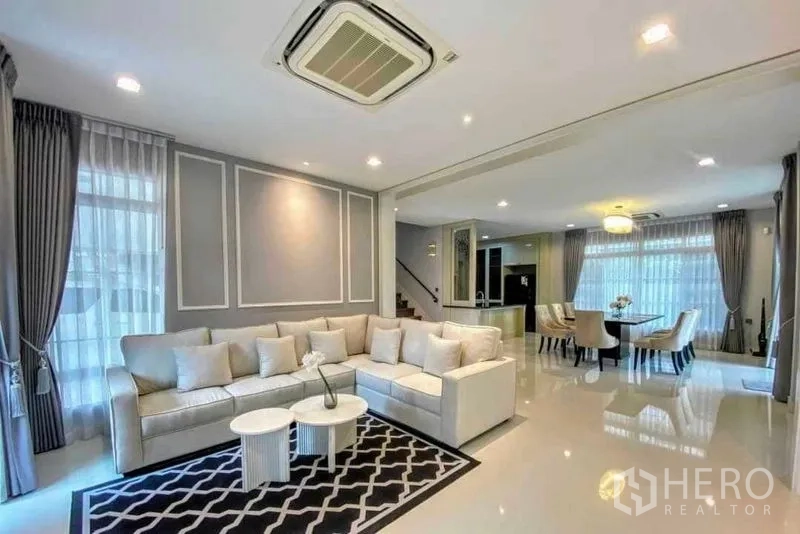 บ้าน ให้เช่าในBang Khen, Bangkok - ห้องนั่งเล่นเชื่อมพื้นที่ทานอาหาร โซฟา L และหน้าต่างสูงจรดเพดาน
