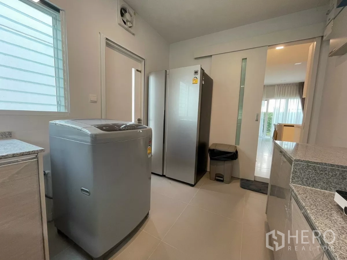Detached House for rent in Prawet, Bangkok - Kitchen and laundry space with washing machine, large refrigerator and sliding door.