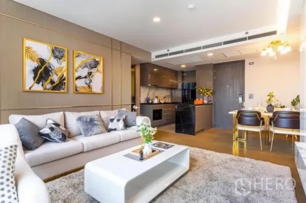 公寓 出租在Khlong Toei, Bangkok - 开放式客餐厅，沙发、挂墙电视与现代厨房相连。
