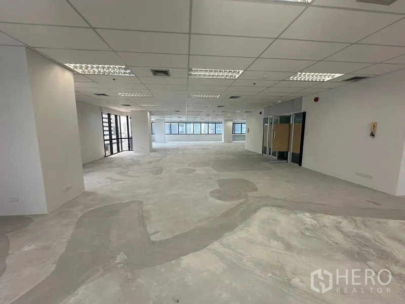 Office Space for rent in Bang Rak, Bangkok - Spacious open workspace showing glass-partition entrance and multiple window lines.