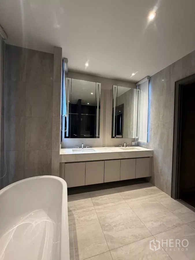 Detached House for rent in Saphan Sung, Bangkok - Contemporary bathroom with freestanding tub and double-sink vanity with mirrors.