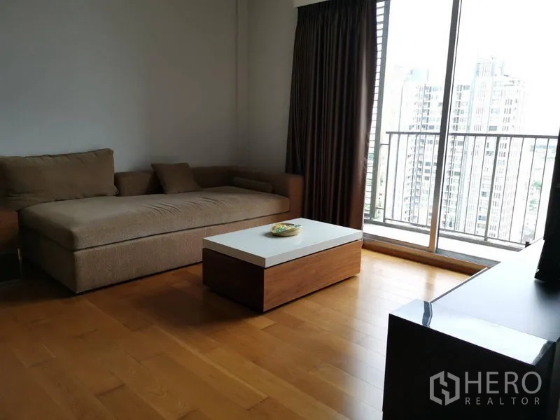公寓 出租在Khlong San, Bangkok - 客厅配转角沙发、矮茶几，连接阳台可观城市景观。