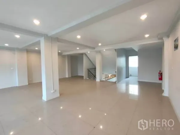 Home Office for rent or sale in Bang Na, Bangkok - Spacious open-plan floor with glossy tiles, recessed lighting, and central staircase.