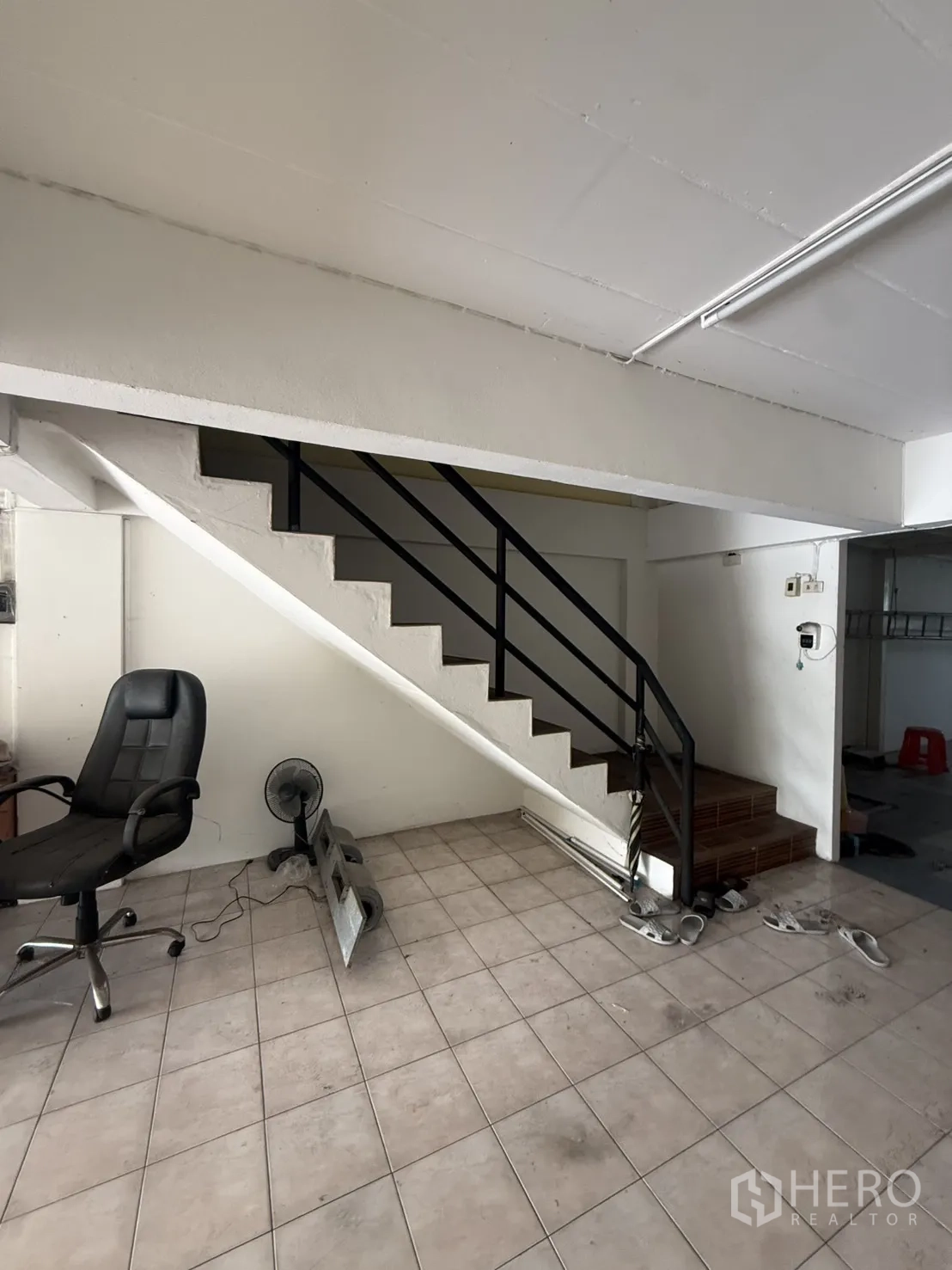 Shophouse for rent in Pak Kret, Nonthaburi - Black-railed staircase rising from the shop area.
