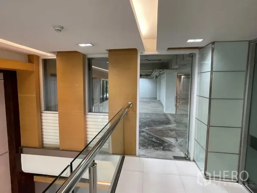 Office Space for rent in Ratchathewi, Bangkok - Building corridor with modern railings and glass entrance to the office suite.