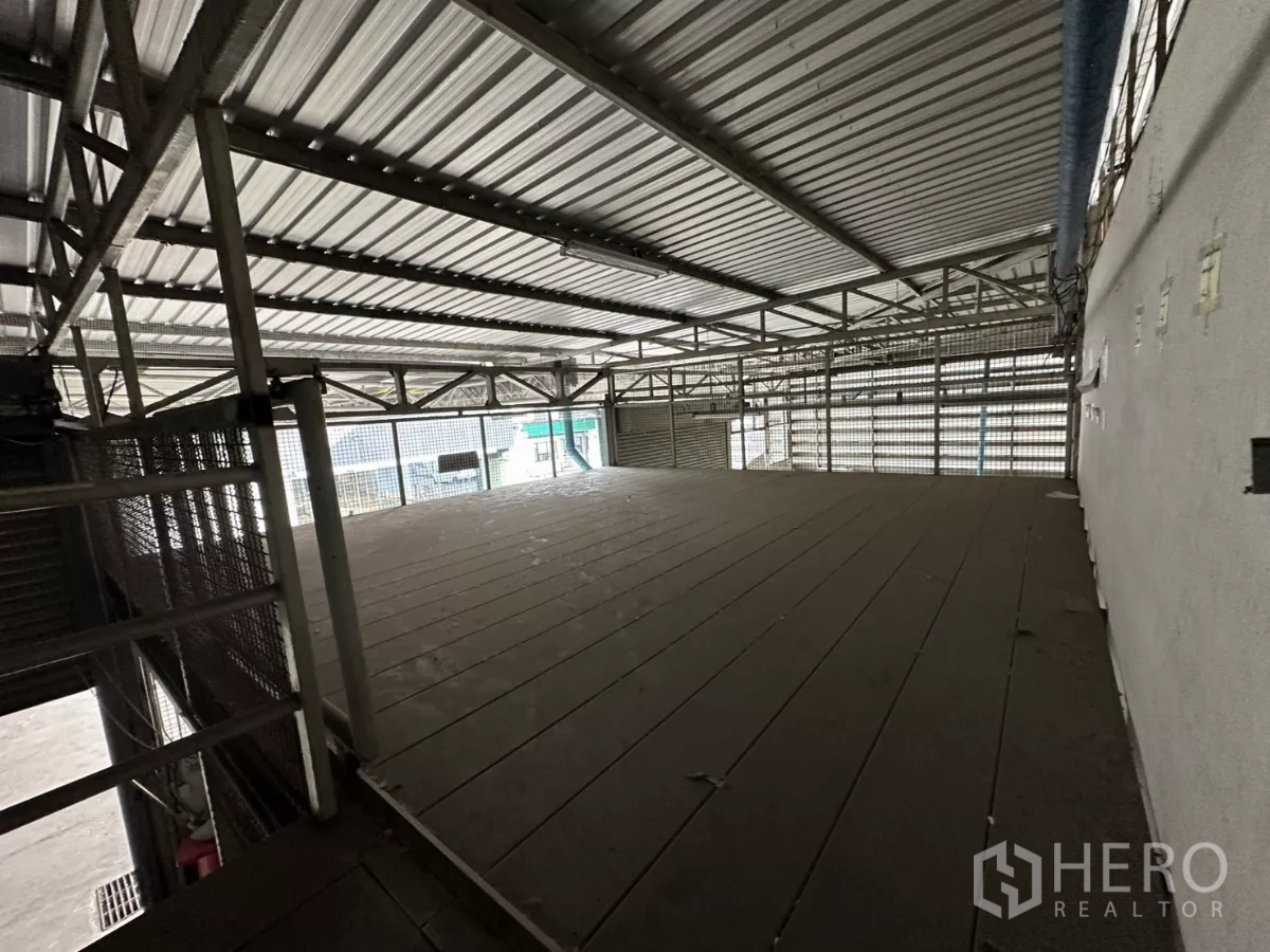 Warehouse for rent in Yan Nawa, Bangkok - Empty mezzanine deck with metal railing and louvered wall for ventilation.