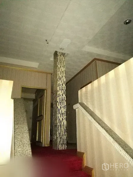 Retail Space for rent in Khlong Toei, Bangkok - Upper-floor landing with mosaic column and carpet, opening to multiple rooms.
