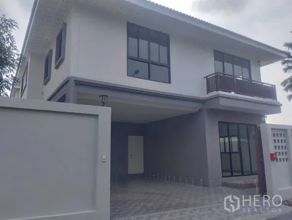 Detached House for sale in Phra Khanong, Bangkok - Front façade of the detached house showing gated wall, tall windows and carport.