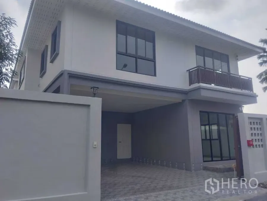 Detached House for sale in Phra Khanong, Bangkok - Front façade of the detached house showing gated wall, tall windows and carport.