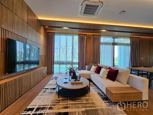 Detached House for rent in Saphan Sung, Bangkok - Media wall with mounted TV, contemporary sofa, and large windows.