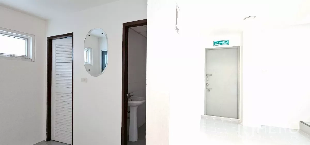 办公空间 出租在Bueng Kum, Bangkok - 走廊，设洗手间入口、墙面镜与消防疏散标识。