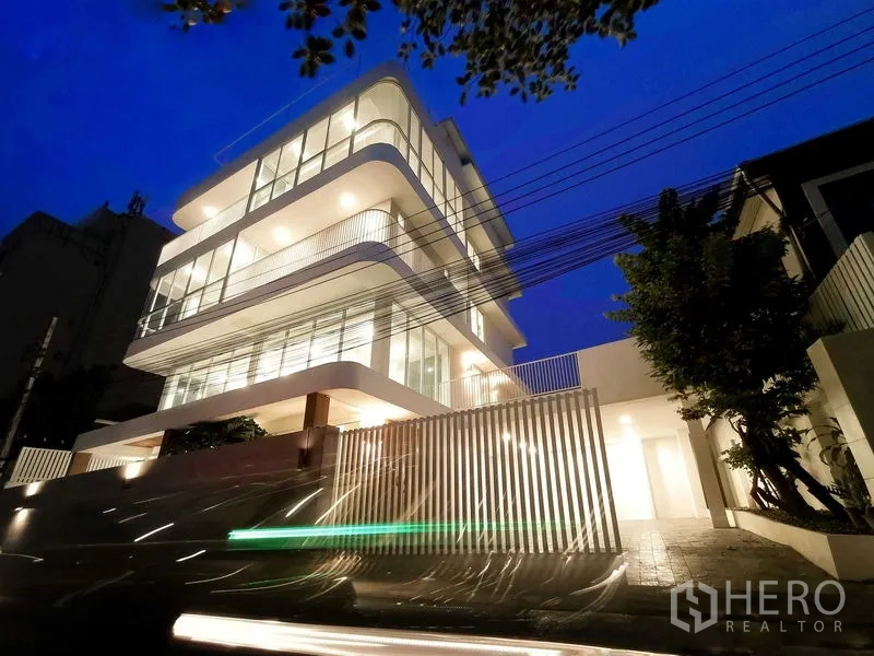 带办公室的家 出售在Suan Luang, Bangkok - 夜景外观，建筑灯光明亮，临静街