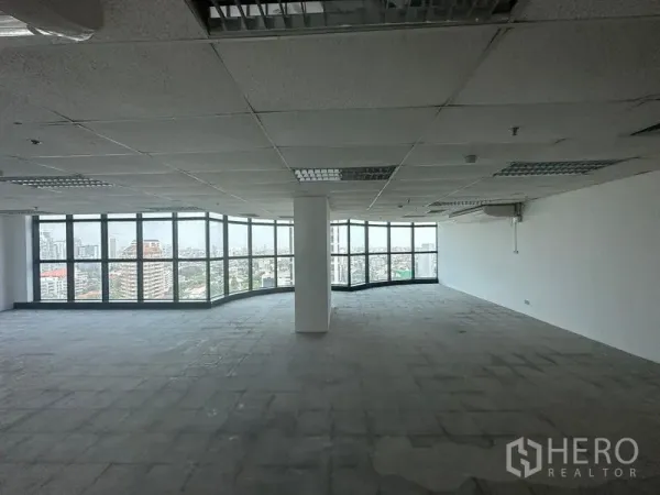 办公空间 出租 - 超大开放式楼层，中央立柱与环绕玻璃窗，远眺城市景观。