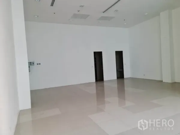 Retail Space for rent in Khlong Toei, Bangkok - Bright white retail unit with polished tiles and two doors to service areas.