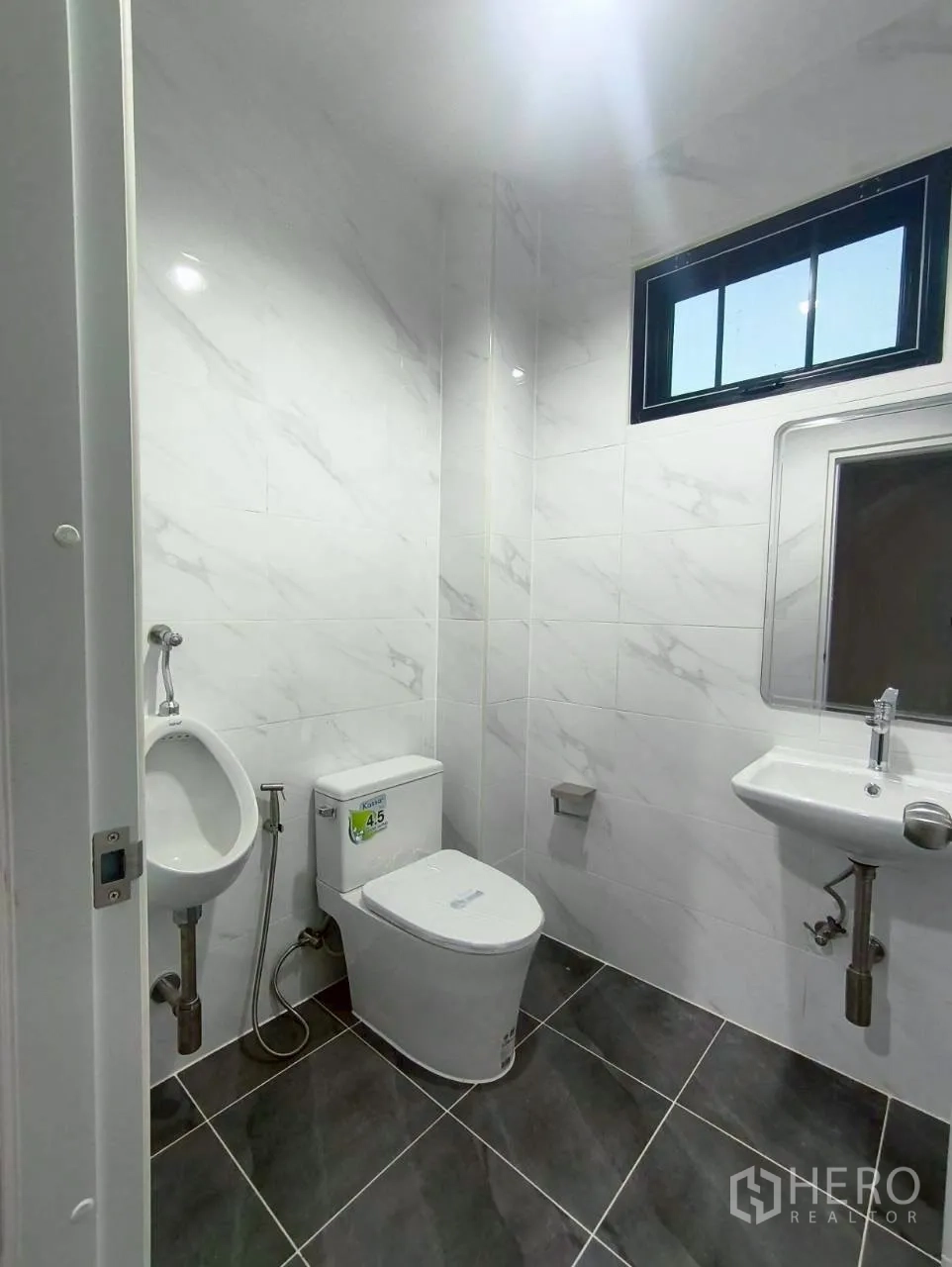 Warehouse for rent in Mueang Nonthaburi, Nonthaburi - Restroom with toilet, urinal, sink, and tiled finishes.