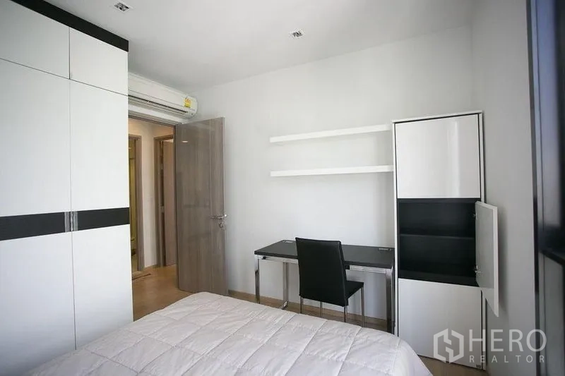 Condominium for rent in Watthana, Bangkok - Second bedroom featuring wardrobe, study desk and floating shelves.