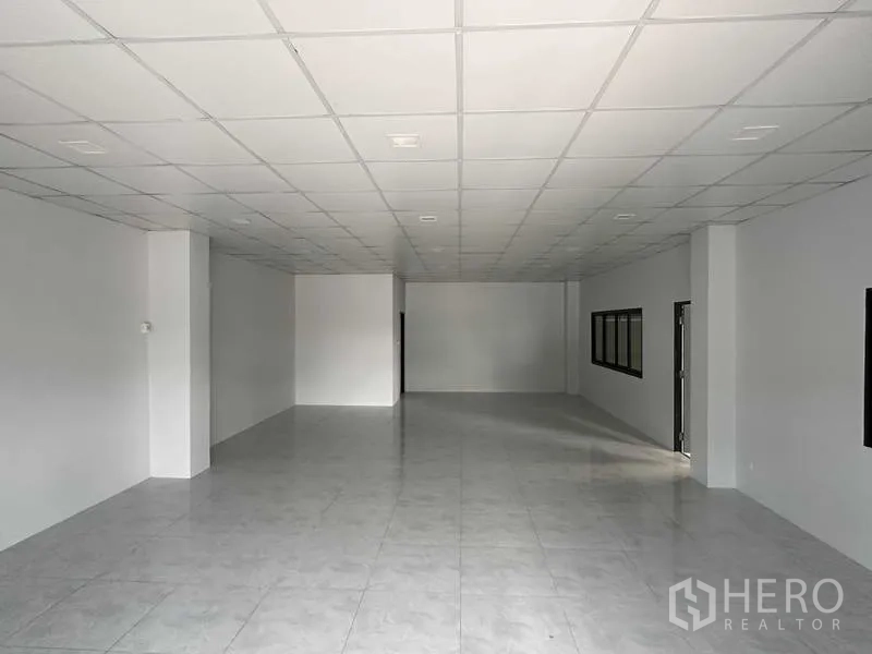 Warehouse for rent in Bang Phli, Samut Prakan - Large office room with tiled flooring, drop ceiling and side windows inside the warehouse.