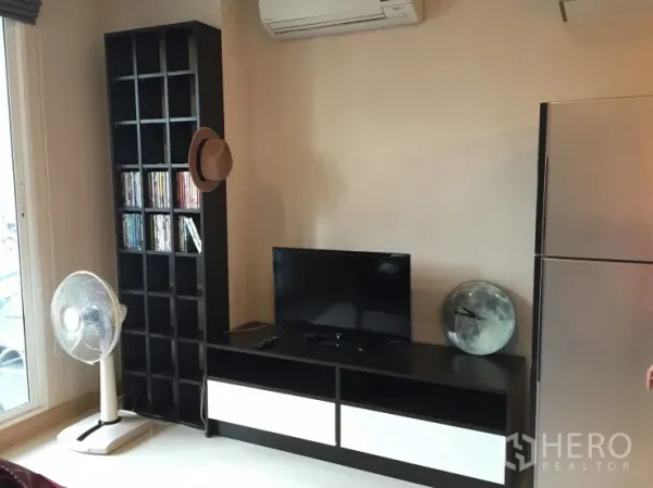 公寓 出租在Watthana, Bangkok - 起居区设电视柜与高置物架，空调与不锈钢冰箱一体布置。