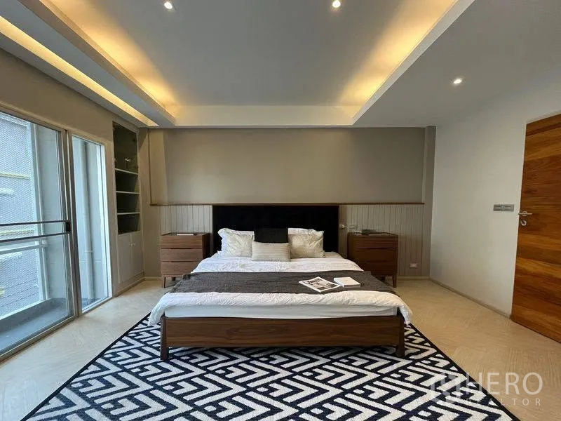 ทาวน์เฮาส์ for rent in Phra Khanong, Bangkok - ห้องนอนใหญ่มีเตียง โต๊ะข้างไฟฝังฝ้า และออกสู่ระเบียงได้.