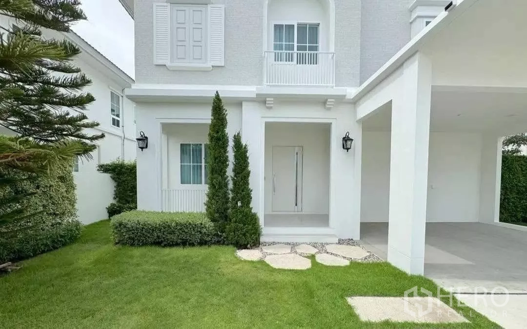Detached House for rent or sale in Bang Phli, Samut Prakan - Front porch with manicured lawn and double carport of the modern home.