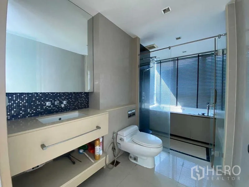 公寓 出售在Ratchathewi, Bangkok - 现代卫浴，宽镜面洗手台、坐便器，玻璃隔断淋浴与浴缸相连。