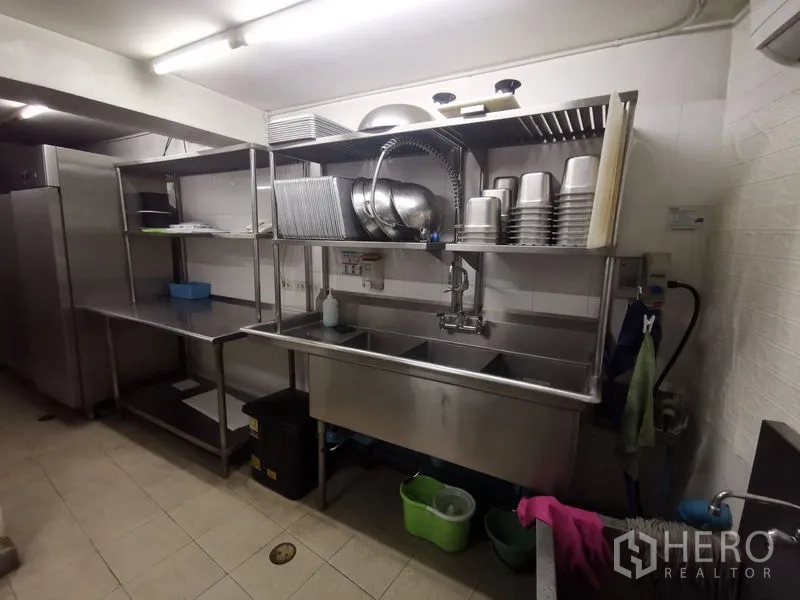Shophouse for rent in Bangkok - Back-of-house dishwashing zone with triple stainless sink and open shelving.