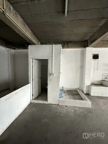 Retail Space for rent in Khlong Toei, Bangkok - Utility corner with a bathroom door and plumbing bases in an unfinished room.