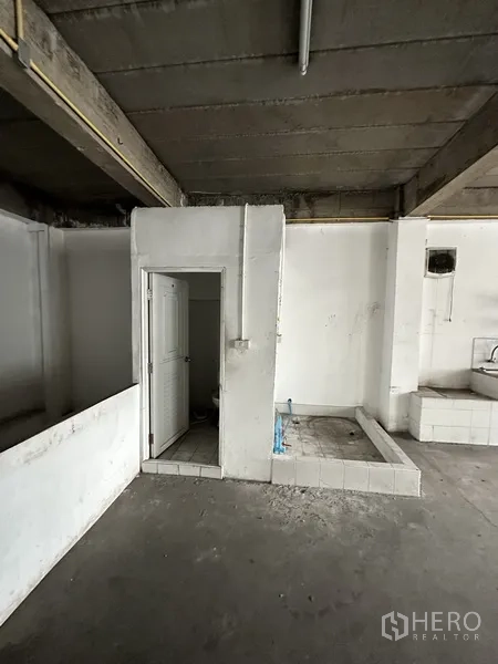 Retail Space for rent in Khlong Toei, Bangkok - Utility corner with a bathroom door and plumbing bases in an unfinished room.