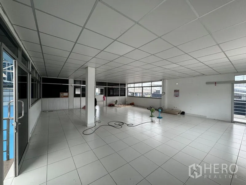 Warehouse for rent in Mueang Pathum Thani, Pathum Thani - Bright upstairs office area with tiled flooring, grid ceiling, and large windows.